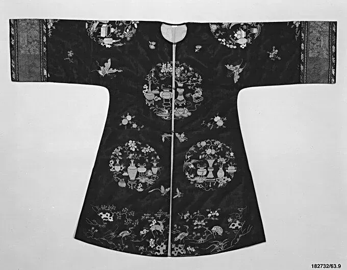 Flach ausgelegte schwarze Damenjacke aus Seidengaze, bestickt mit runden Medaillons voller antiker Gefäße und mit gemusterten Borten an den weiten Ärmeln